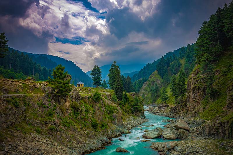 Photographer capturing Aharbal Waterfall at golden hour