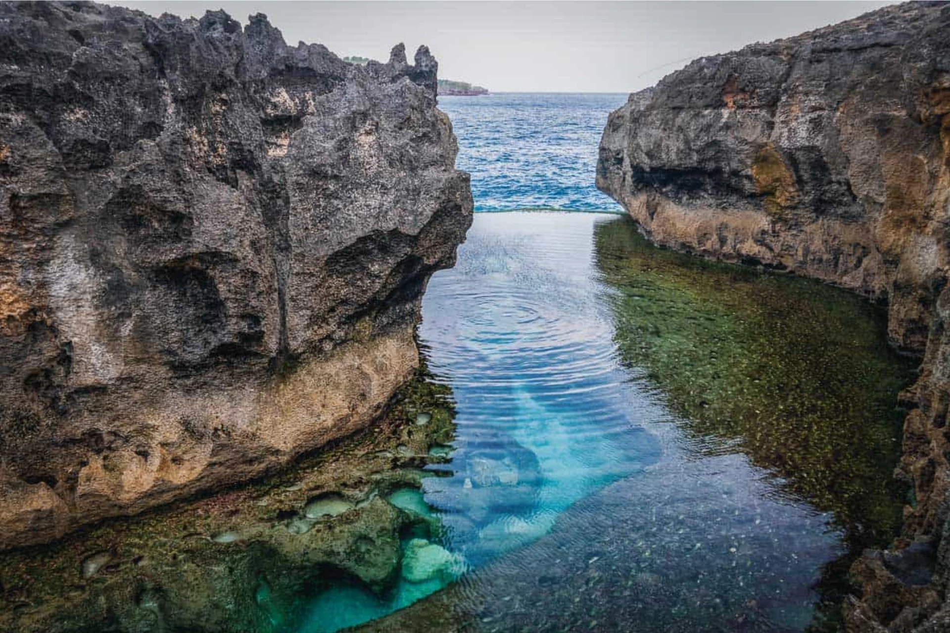 Rocky edge safety zone at Angel s Billabong with ocean surge warning context
