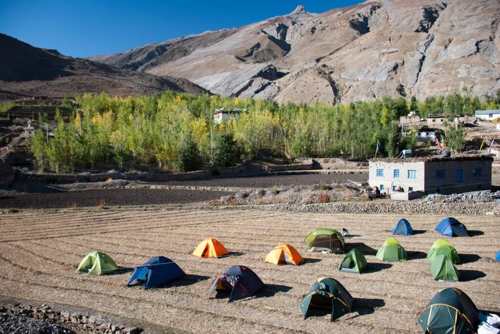 Camping tents in Spiti Valley with majestic mountains and clear blue sky