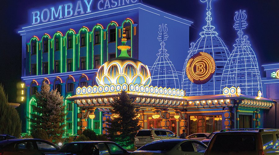 Casino interior in Almaty at night with bright lights and gaming tables