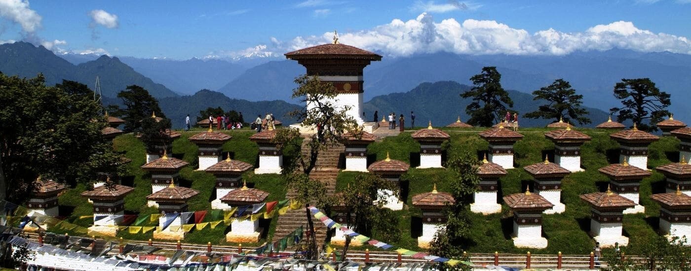 The 108 sacred chortens at Dochula Pass Bhutan with Himalayan mountains in background