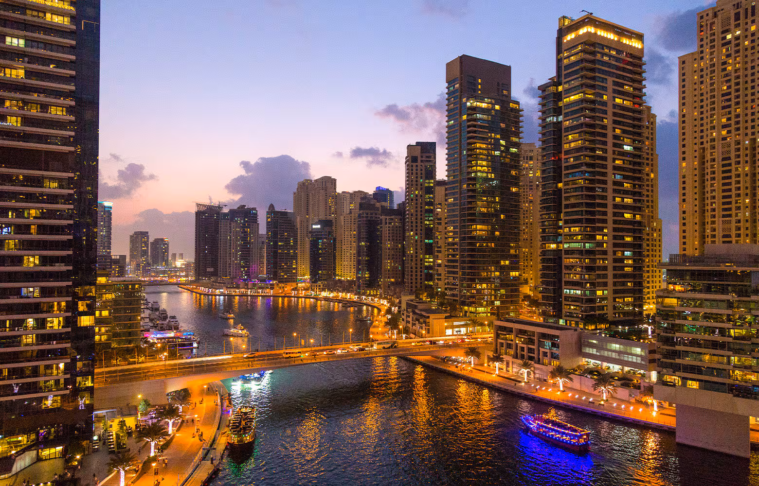 Dubai Marina at night with illuminated buildings and yachts