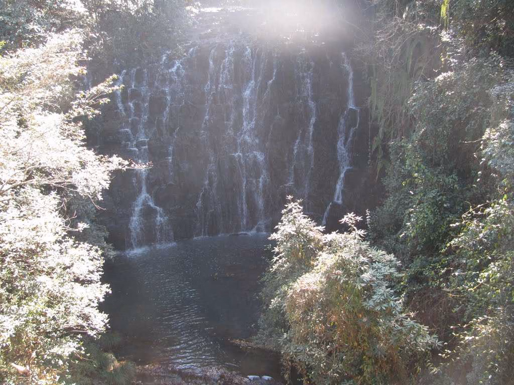 Photographer capturing Elephant Falls with camera on tripod