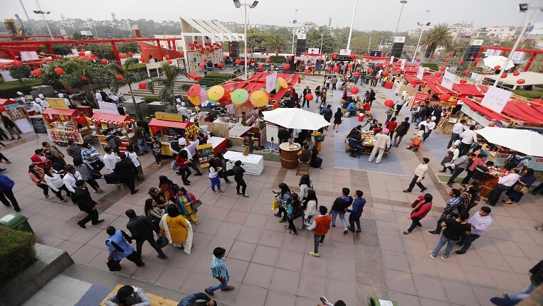 Evening food festival lights and crowd enjoying regional Indian cuisine
