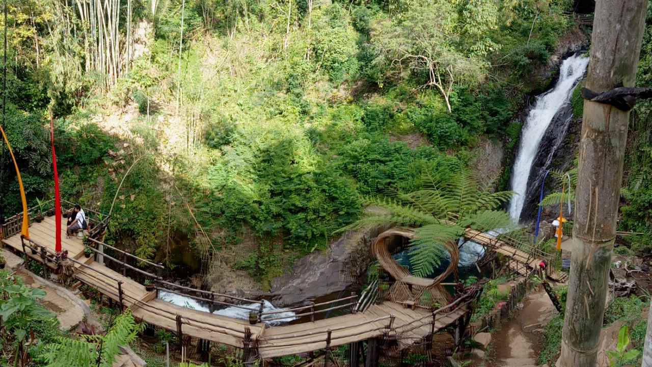 Paved path through tropical forest leading to Gitgit Waterfall