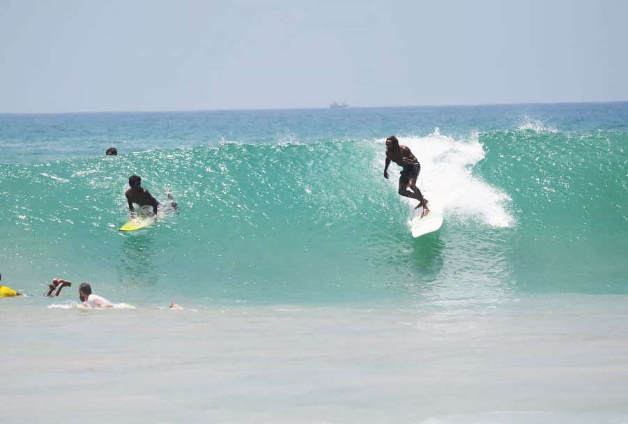 Surfers riding waves near Hikkaduwa and Narigama Beach