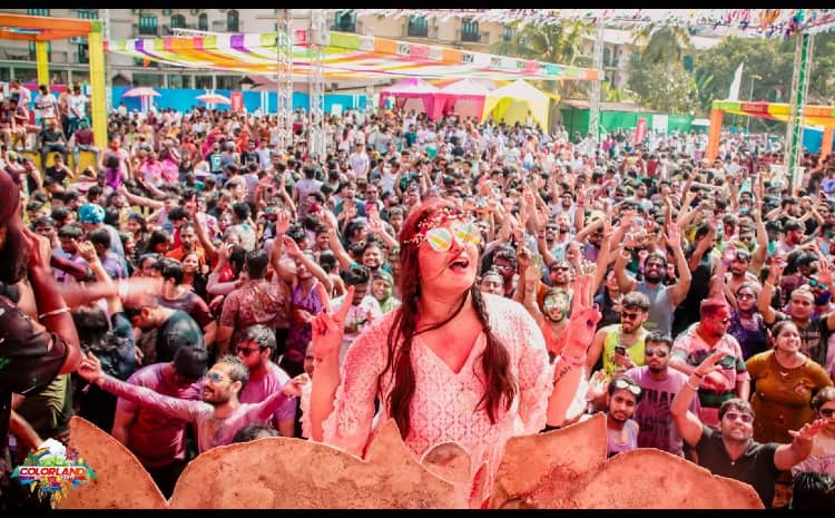 Holi celebration on Goan beach with people throwing colors