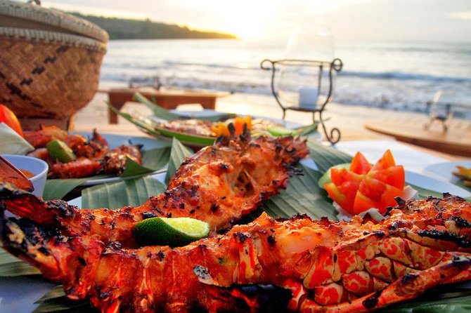 Beachfront seafood dinner setup at sunset in Jimbaran