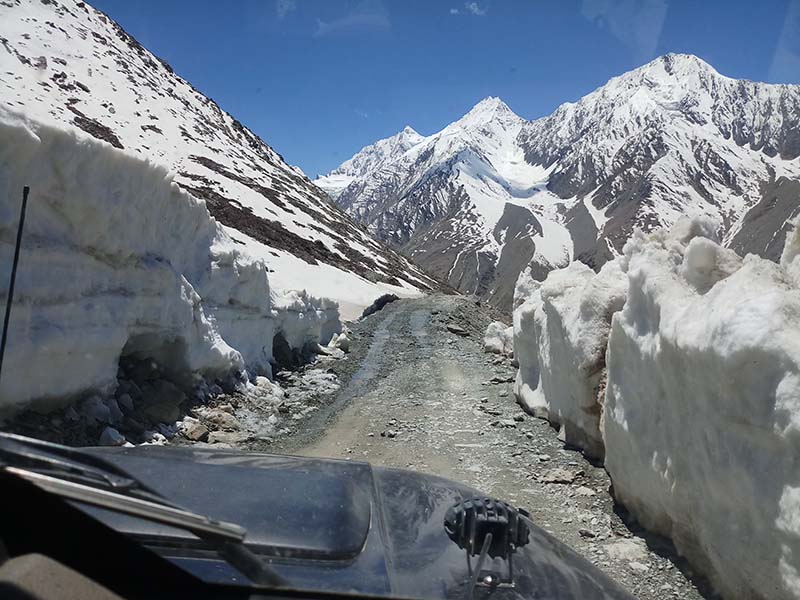 Mountain road and prayer flags at Kunzum Pass in Himachal