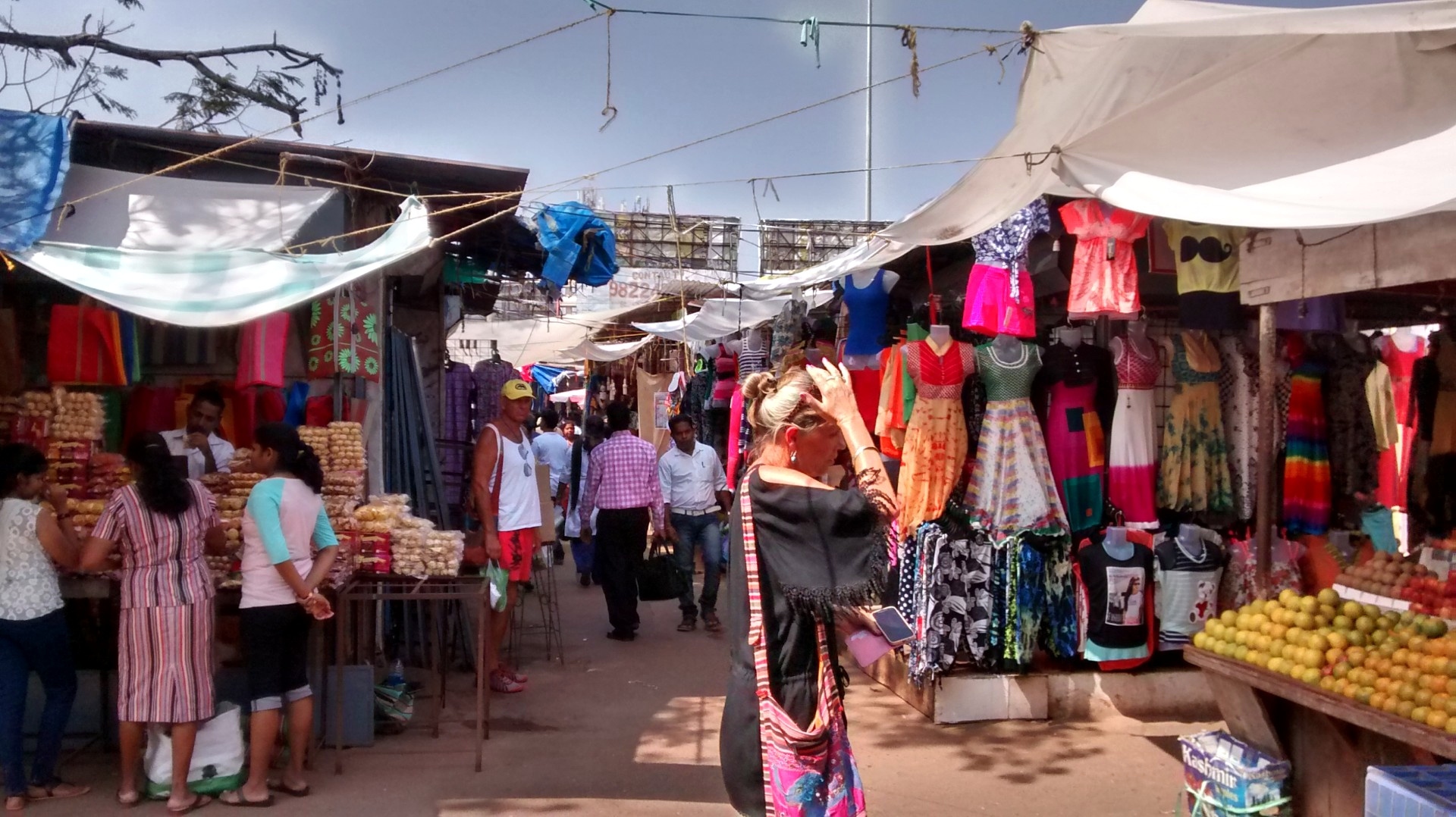 Mapusa Friday Market lanes with clothing and household stalls