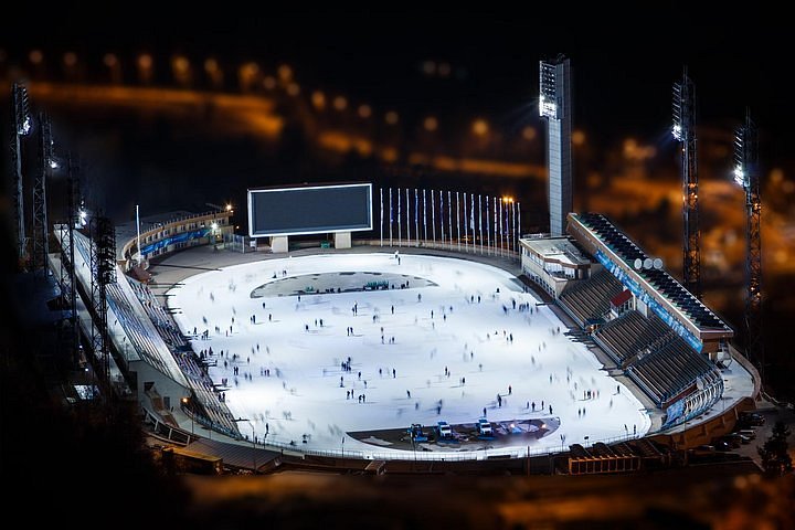 Night skating at Medeu Rink with floodlights illuminating the ice against dark mountains