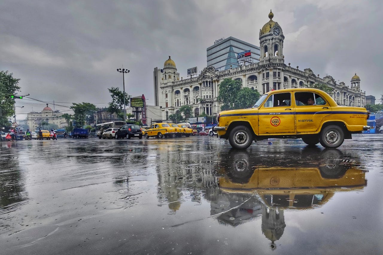 Kolkata streets during monsoon with puddles and heritage buildings
