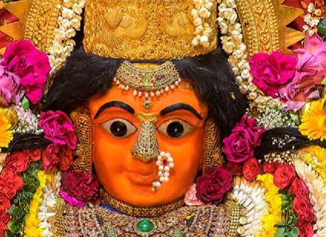 Goddess Mumba Devi idol in orange with traditional ornaments