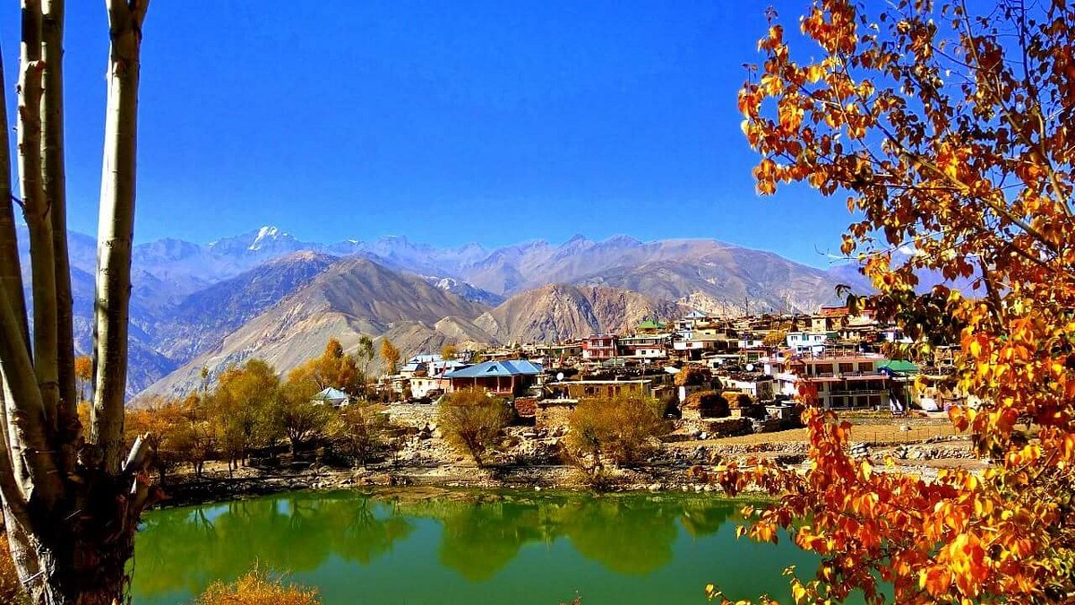 Mirror reflection of mountains in Nako Lake's crystal clear waters