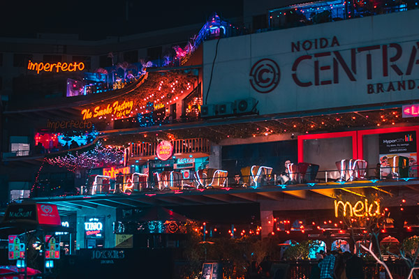Evening crowd and retail lights in Noida shopping district