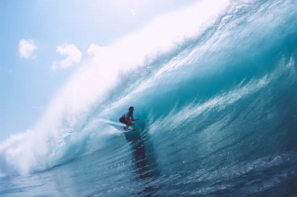 Surfers riding waves at Padang Padang Beach