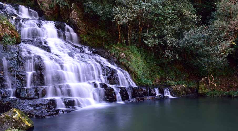 Krang Suri Falls turquoise pool in monsoon