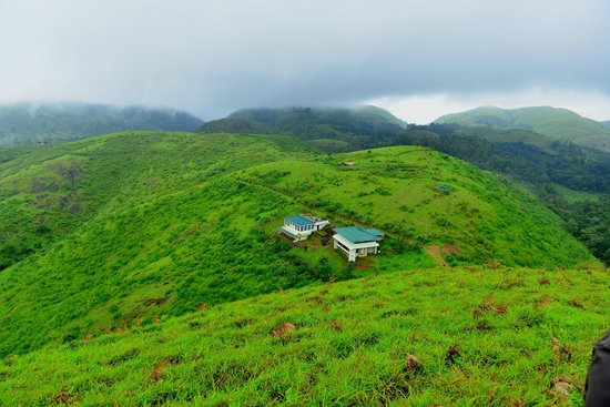 Rolling green meadows of Vagamon with mist-covered hills in the background