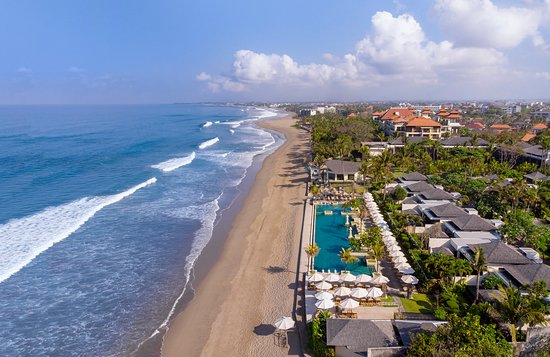 Wide sandy stretch of Seminyak Beach Bali with sunset sky