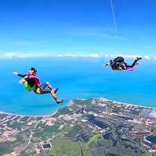 Skydiver in freefall over Thailand's tropical landscape