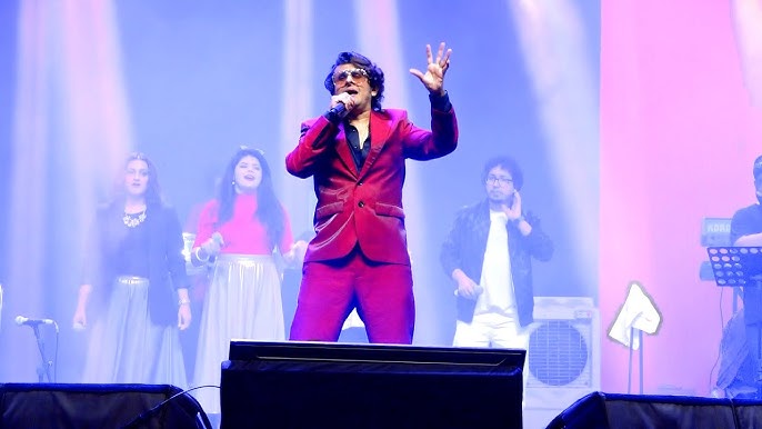 Sonu Nigam live concert stage setup with orchestra and lights