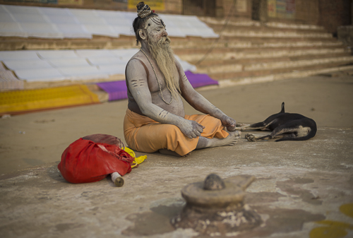 Sadhu meditating on Varanasi ghat at sunrise