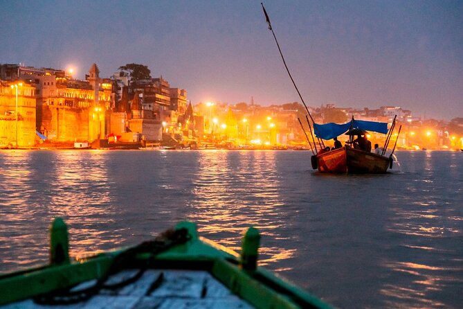 Sunset boat ride in Varanasi with river reflections and lit ghats