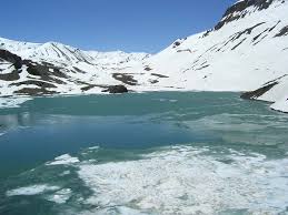 Mountain reflection and cold blue water at Suraj Tal high-altitude lake