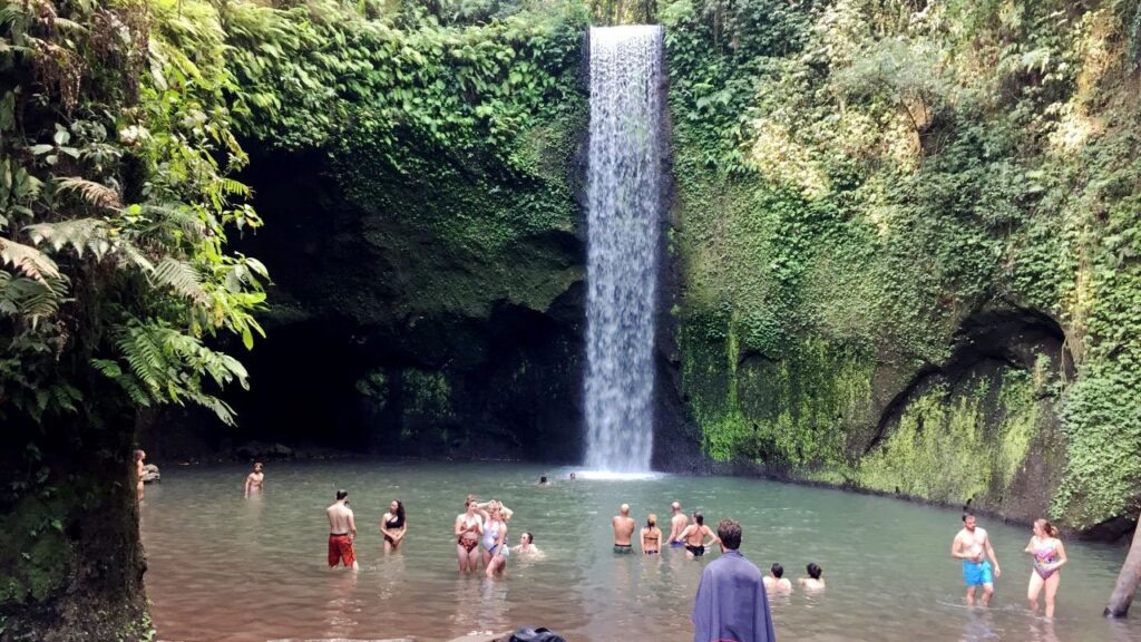 Swimmers enjoying the crystal clear natural pool at Tibumana Waterfall