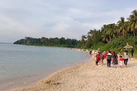 Travelers walking on Wandoor Beach shoreline