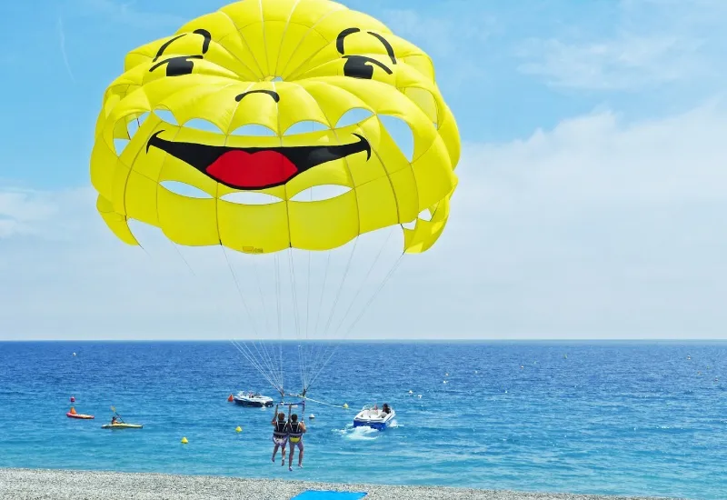 Parasailing activity at Diu beach with colorful parachute