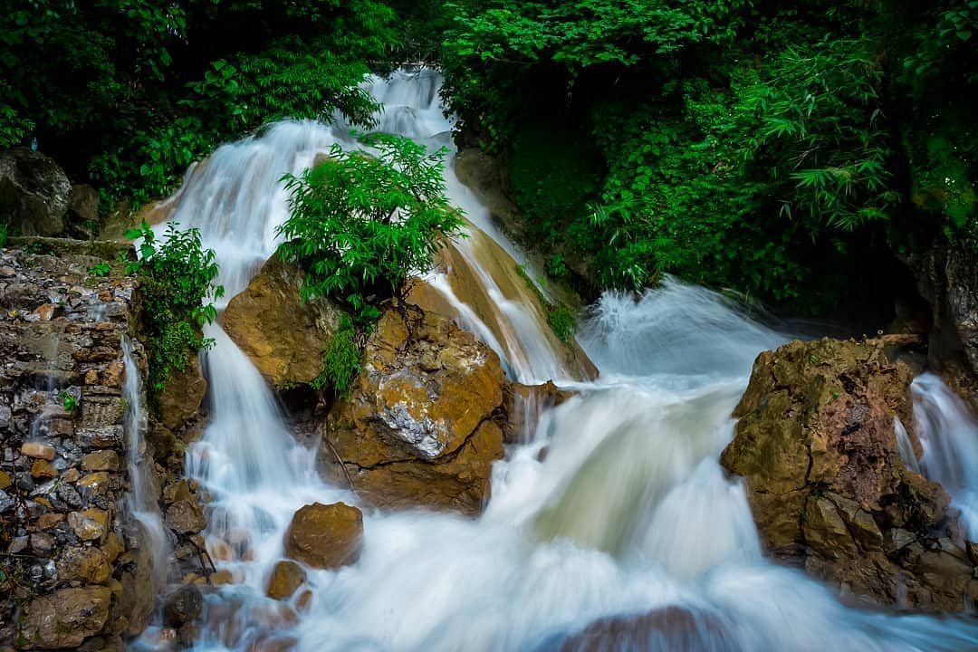 Beautiful waterfall in Rishikesh surrounded by lush greenery